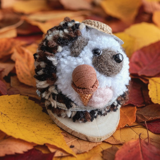 Small plush hedgehog holding an ice cream wearing a hat