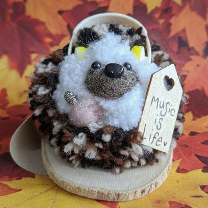 Plush hedgehog with a wooden tag on a wooden surface