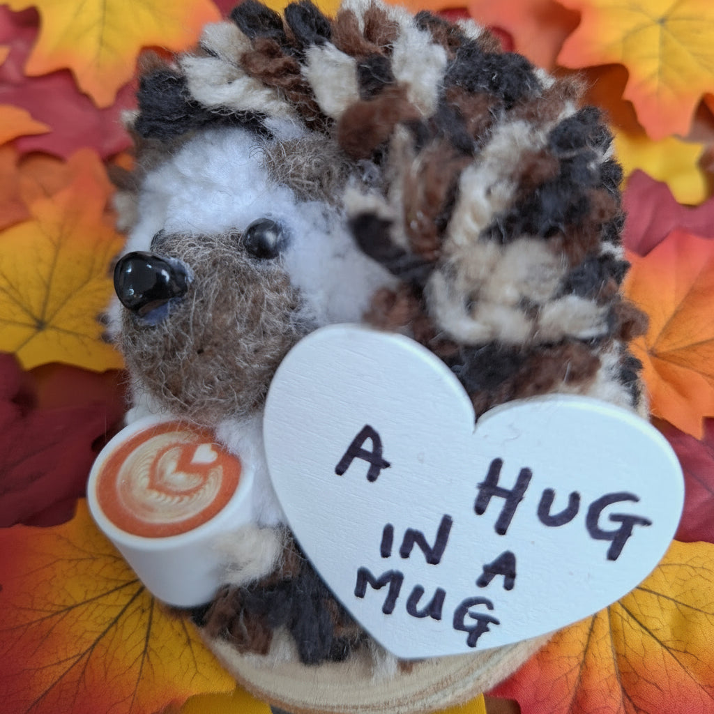Hedgehog-shaped wool ornament with a heart-shaped tag on a wooden surface