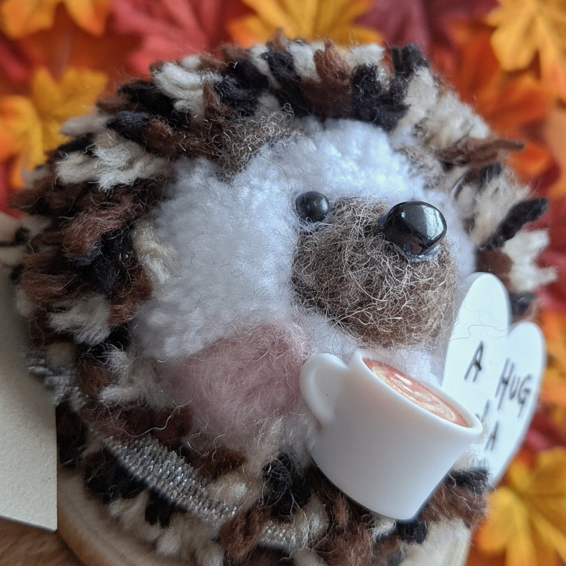 Plush toy hedgehog with a white tag on a blurred background
