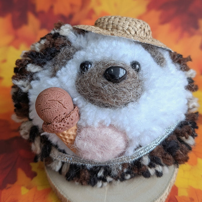 Plush thedgehog on a wooden disc wearing a hat and holding an ice cream