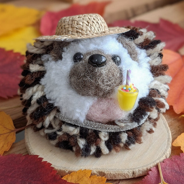 Hedgehog plush toy with a straw hat holding a milkshake