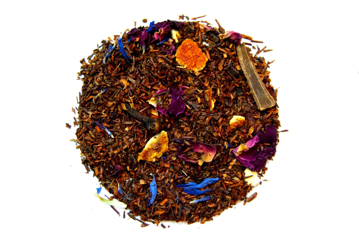 Loose Orange and Cinnamon rooibos blend with orange peel, cinnamon and colourful flower petals on a white background
