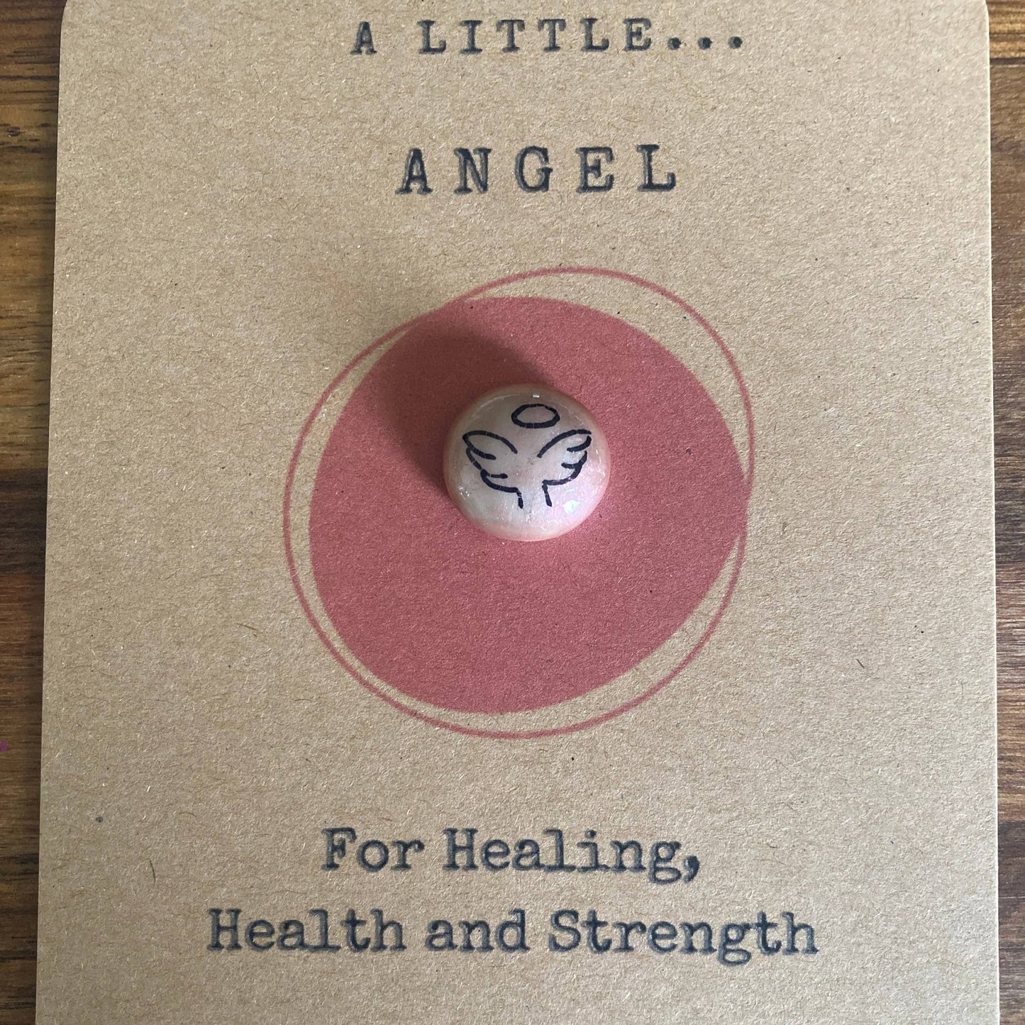 Small angel figurine on a card with text about healing, health, and strength.