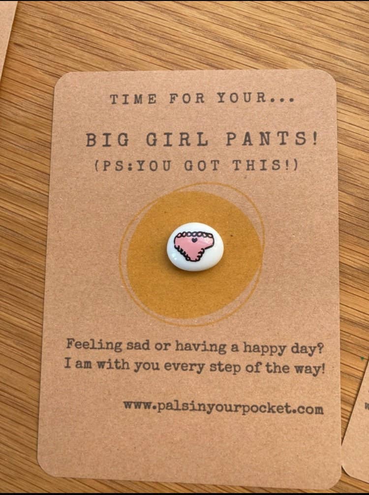 Card with a charm and text on a wooden surface