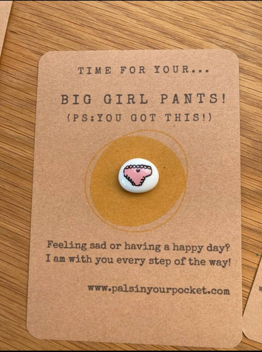Card with a charm and text on a wooden surface