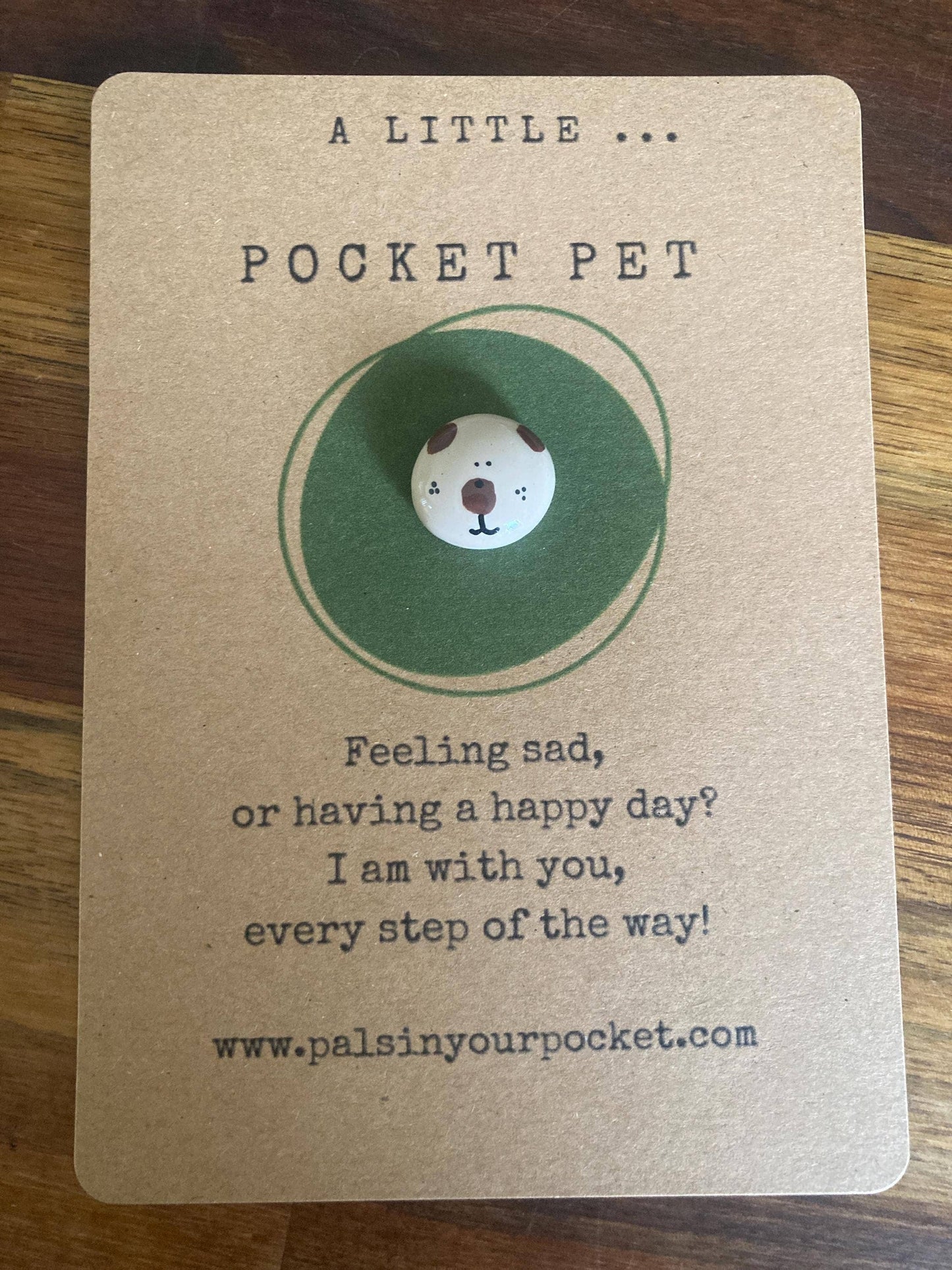 Card with a small round pocket pet on a brown background