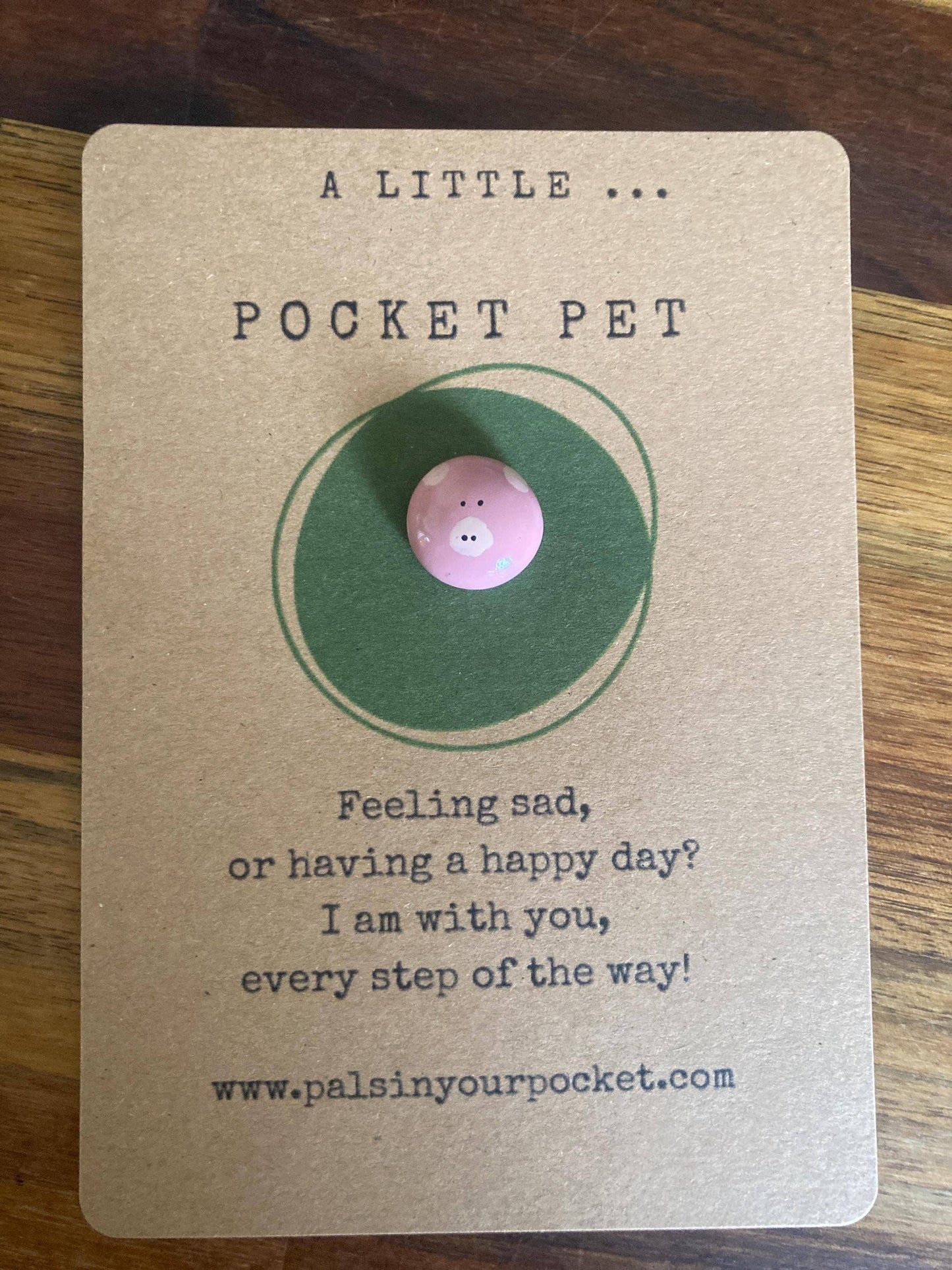 Card with a pig token labeled 'Pocket Pet' on a wooden surface