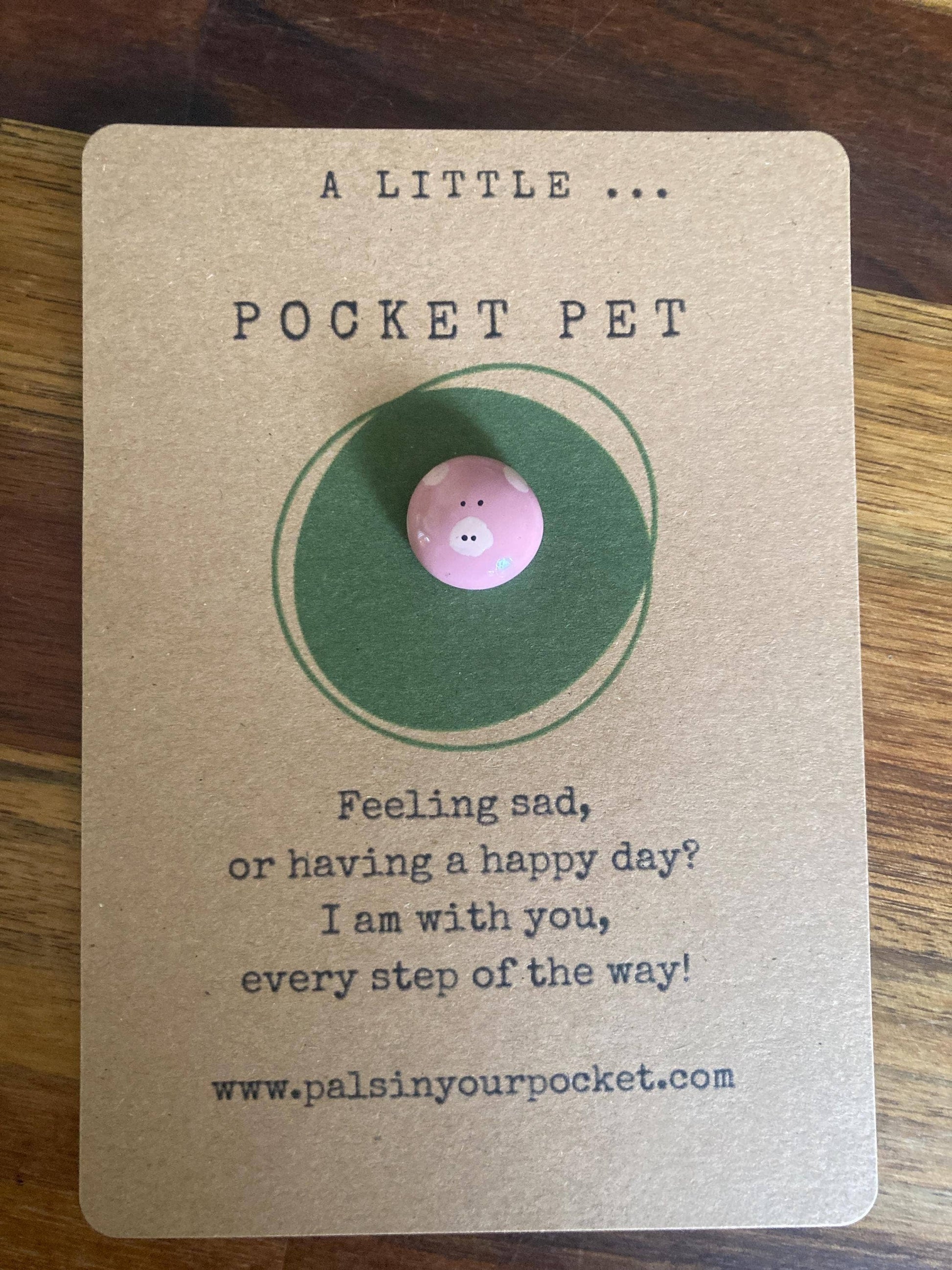 Card with a pig token labeled 'Pocket Pet' on a wooden surface