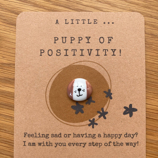 Card with a small round token featuring a dog face design on a brown background.