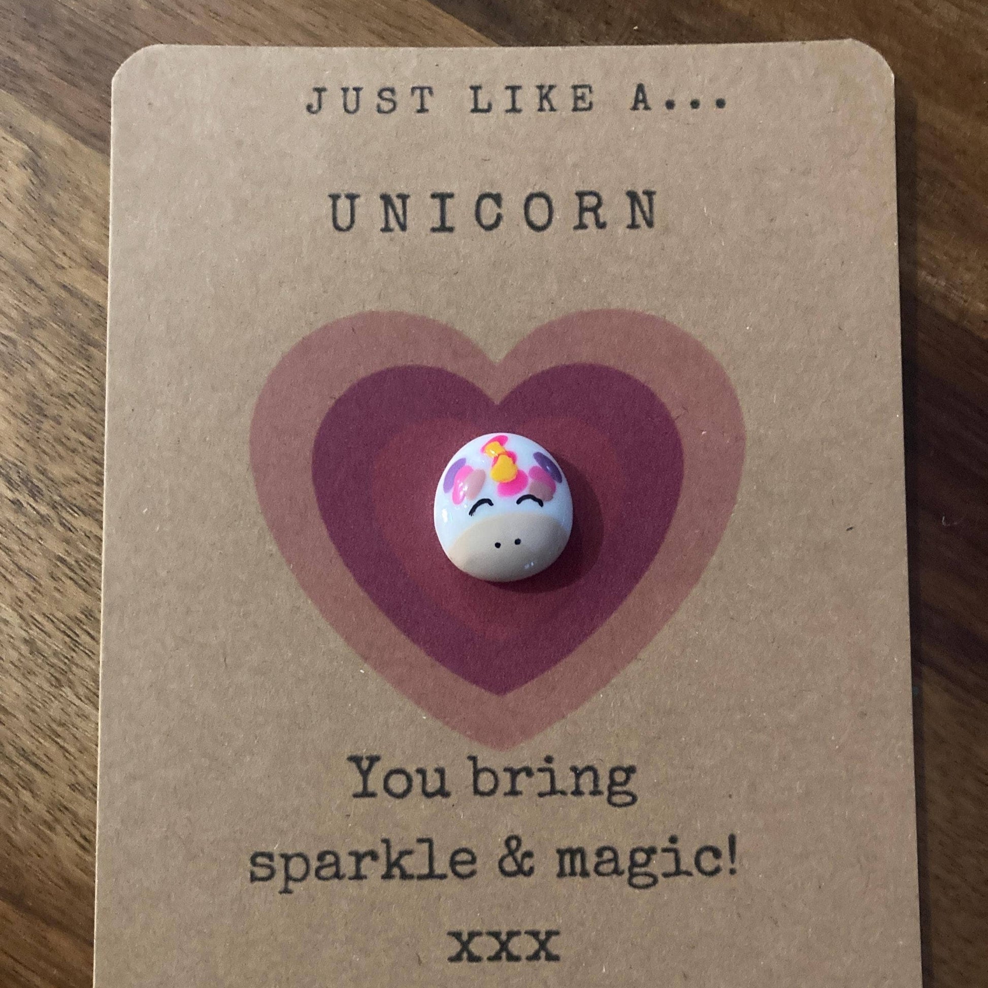charm with unicorn design on a heart-shaped card with text