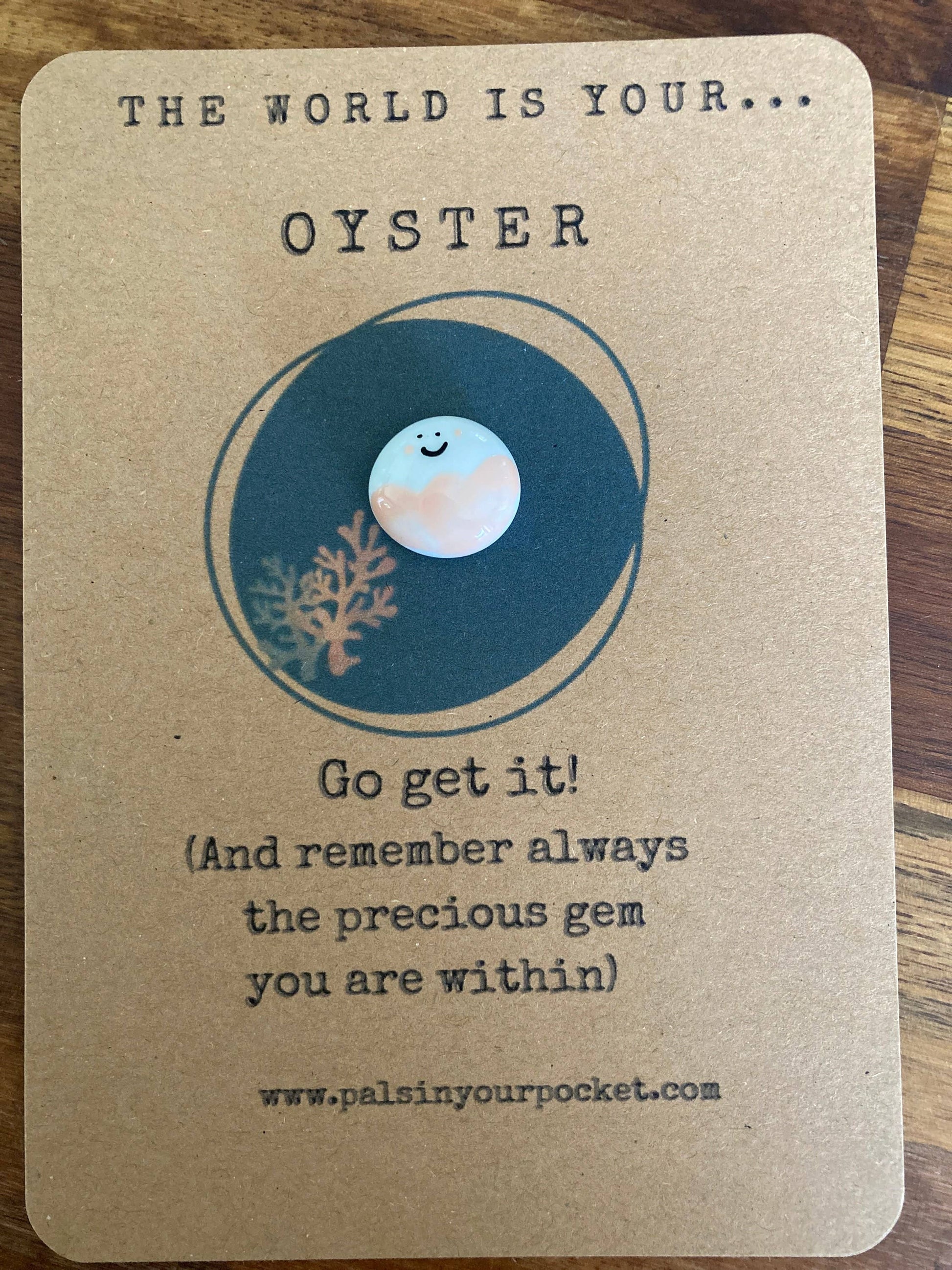 Motivational card with ocean-themed design and text on a wooden surface