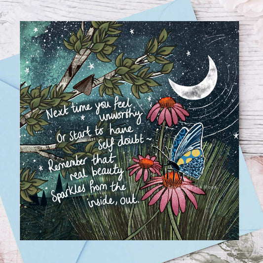 Greeting card with butterfly, flowers, and motivational quote against a night sky background.