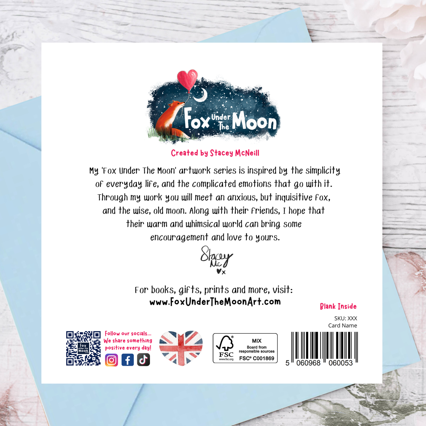 Back of a card with 'Fox Under The Moon' branding and text on a light blue envelope.