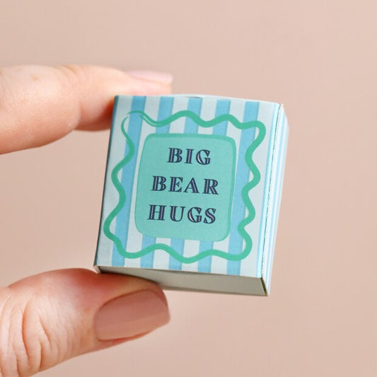 Small box with 'Big Bear Hugs' text held by a hand against a beige background