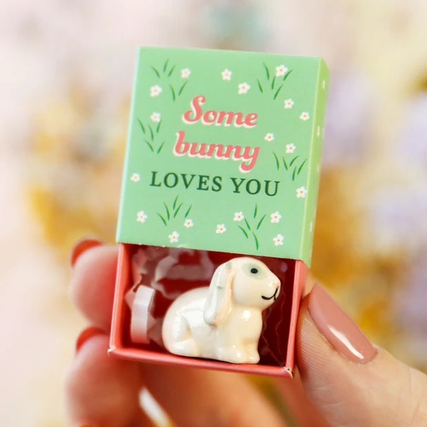 Hand holding the Some Bunny Loves You matchbox showing the green lid with floral design