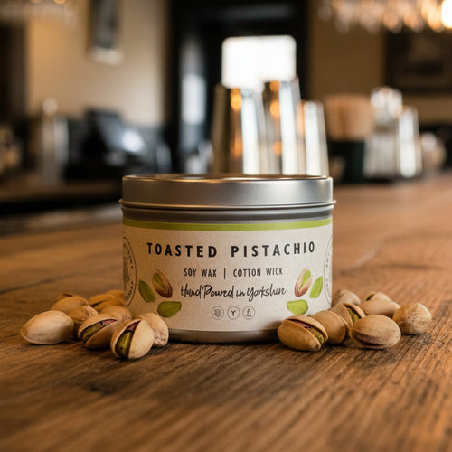 Toasted Pistachio candle on a wooden surface with pistachios around