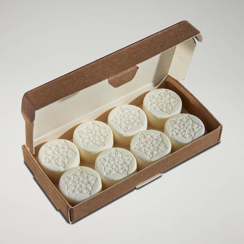 Box of white cylindrical products with yorkshire rose patterns on a light gray background