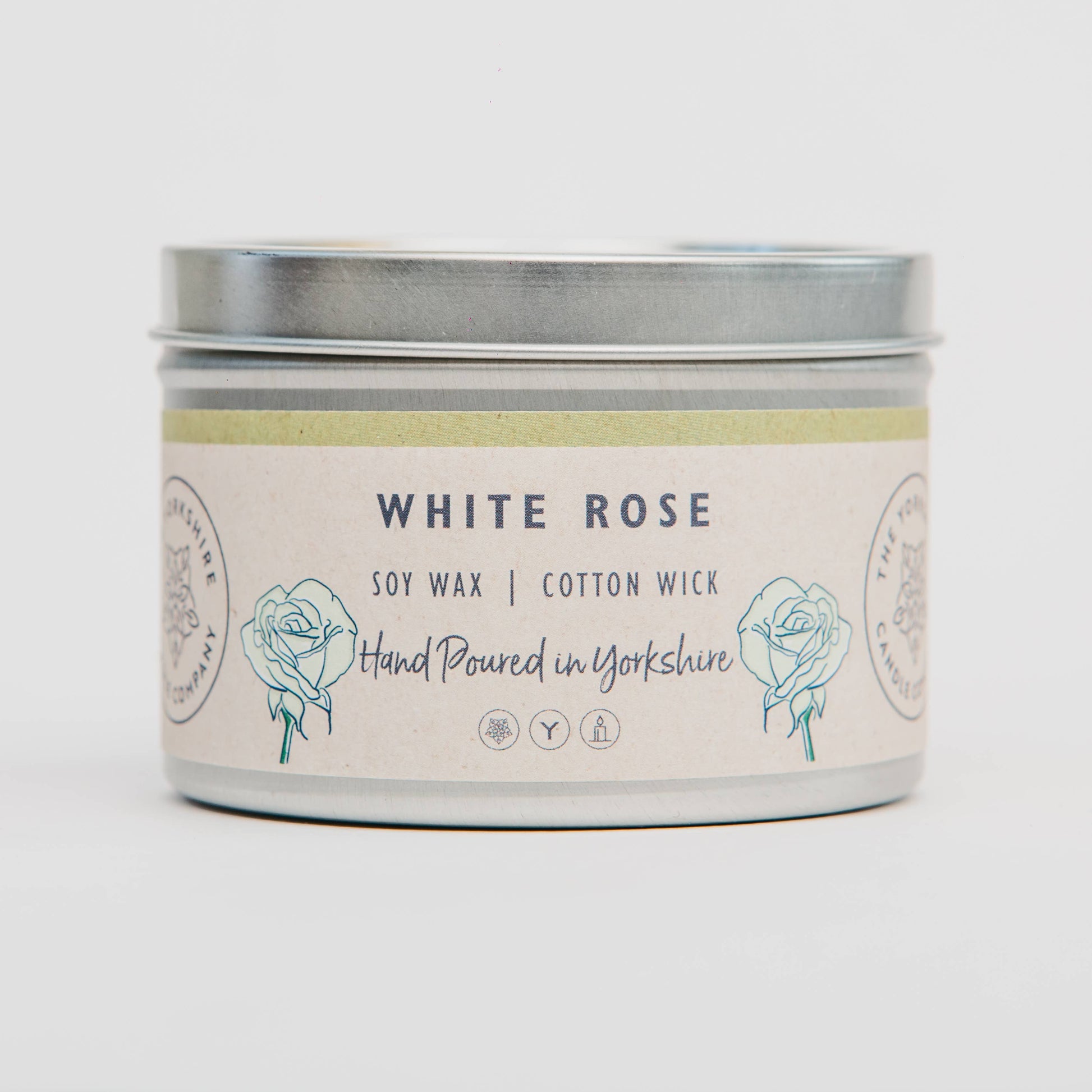 Candle tin labeled 'White Rose' with soy wax and cotton wick on a light background