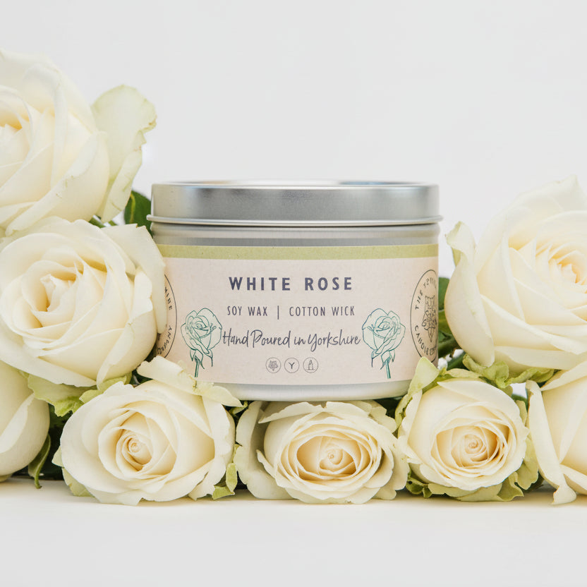 Candle tin labeled 'White Rose' with soy wax and cotton wick 