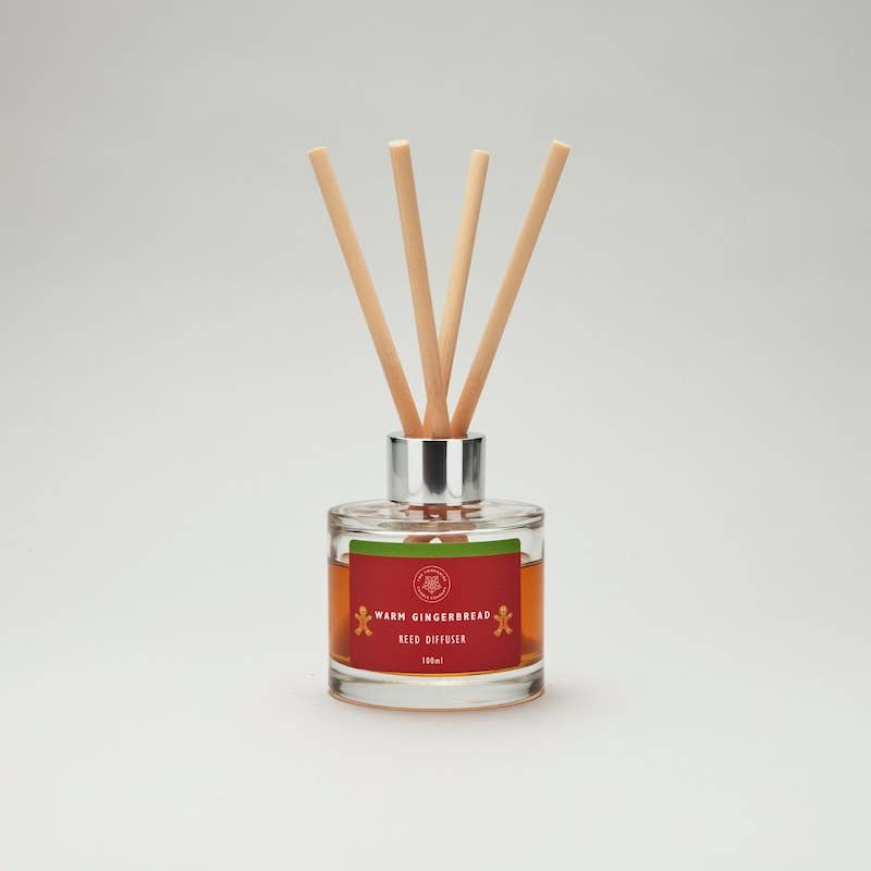 Warm Gingerbread reed diffuser with amber liquid, a red label and four pale reeds