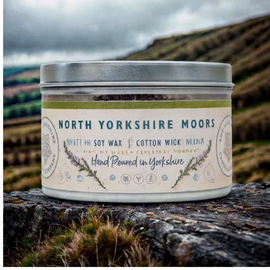 Candle in a tin labeled 'North Yorkshire Moors' on a natural background